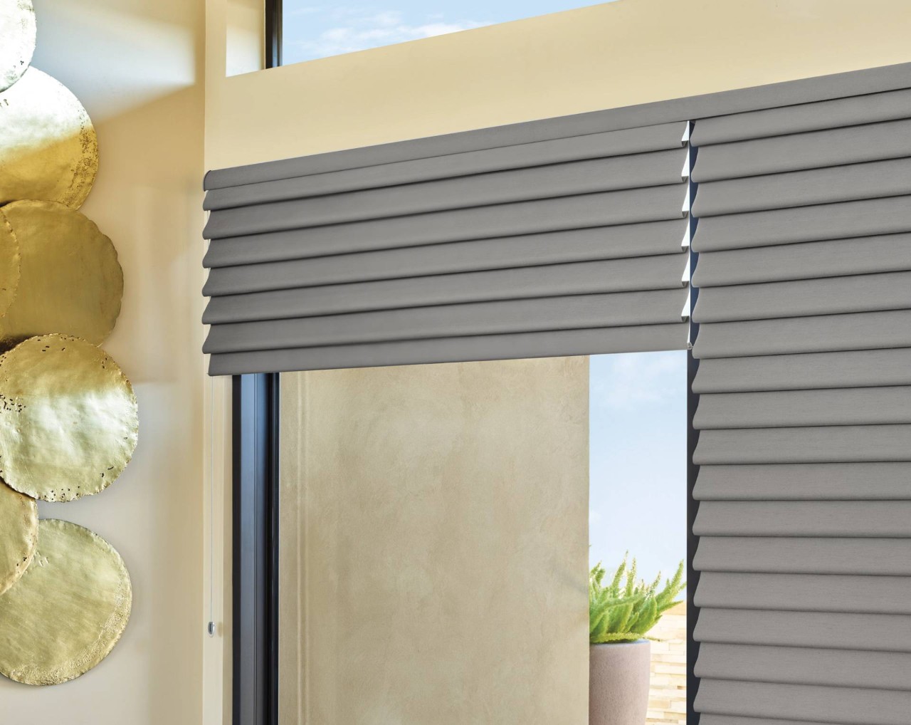 Hunter Douglas Vignette® Roman Shades with black window trim and gold-finished wall accents near Cape Coral, Florida (FL)