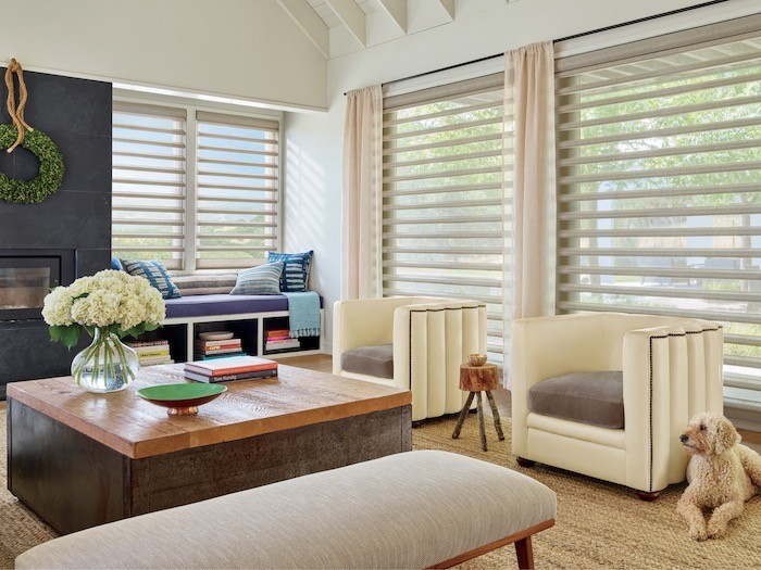 A living room with coffee table that has 3 elements, a vase, a bowl, and a stack of books.